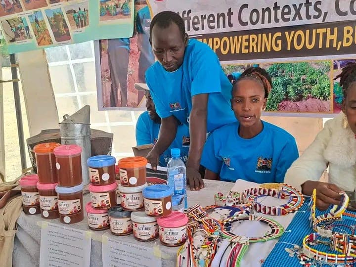 A youth enterprise stand displaying jars of honey and Maasai beadwork at National Youth Day in Kajiado