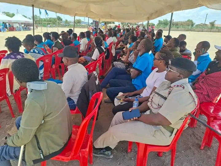 Community members and a Kajiado County official seated under an event tent at National Youth Day