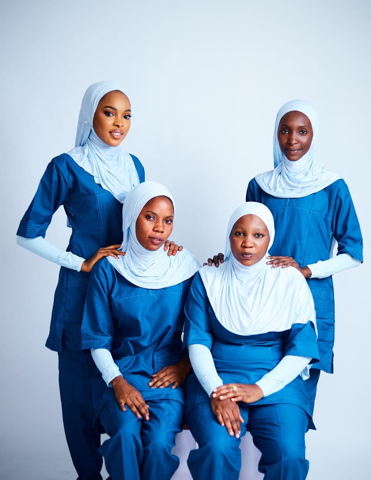 Four community health workers in matching uniforms, standing together
